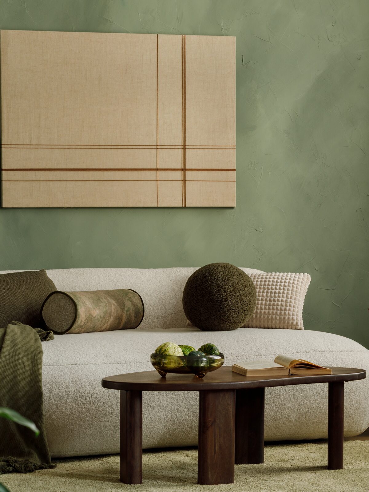 A United Stay living room styled with a cream sofa and soft green walls