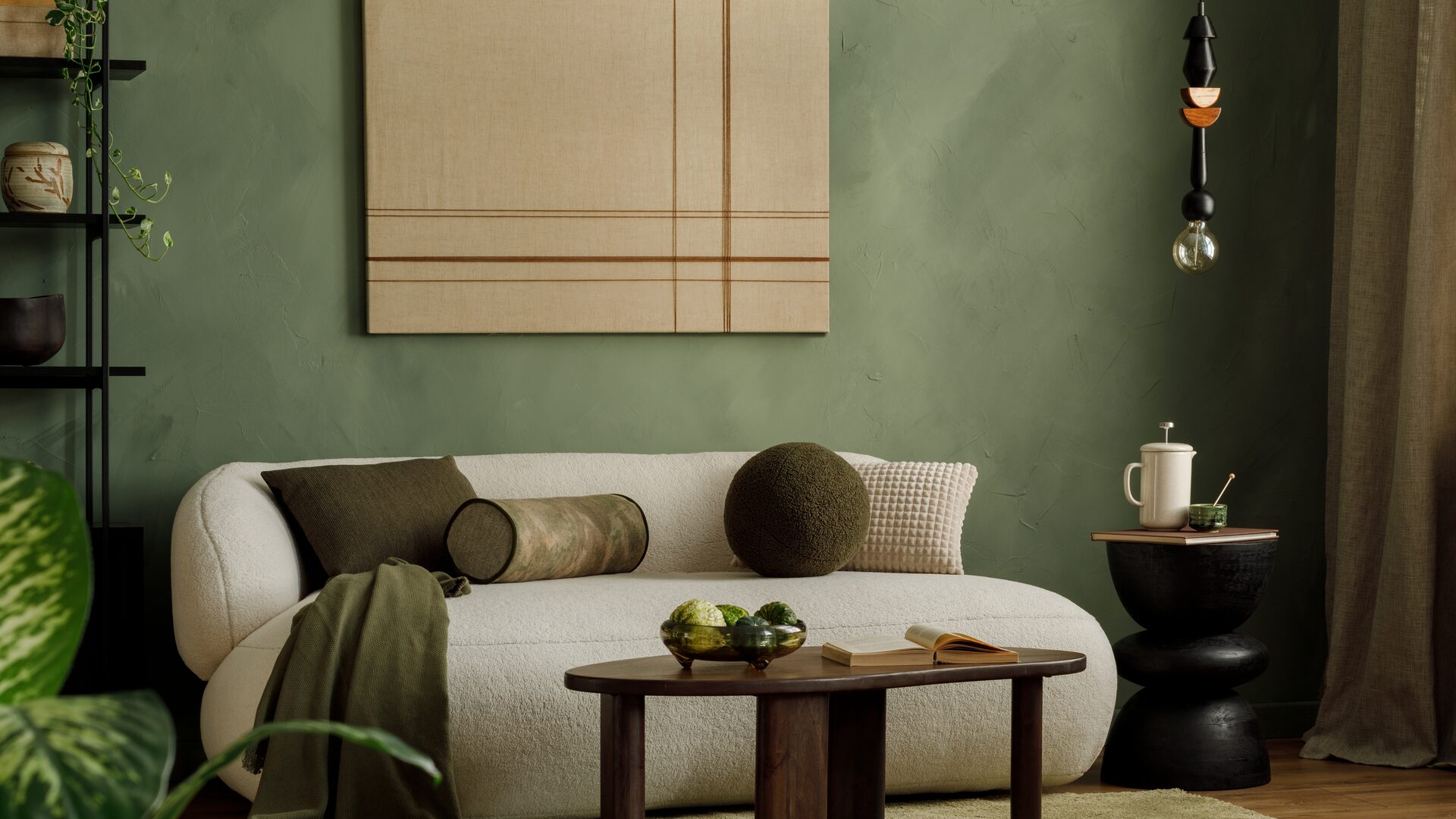 A United Stay living room styled with a cream sofa and soft green walls